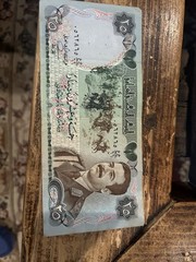 1986 Iraqi 25 Dinar banknote featuring a portrait SaddamHussein militaryUniform